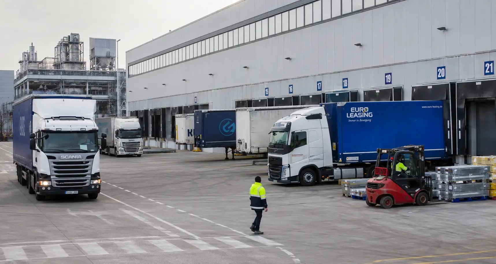 muelles de carga en fábrica industrial con varios camiones coordinando ventanas de expedición